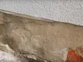 Fragment ściany z widoczną warstwą izolacji i miejscem na iniekcję.