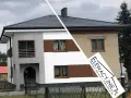 Nowy, nowoczesny wygląd domu po malowaniu elewacji. Stara, zniszczona ściana kontrastuje z odnowioną fasadą.