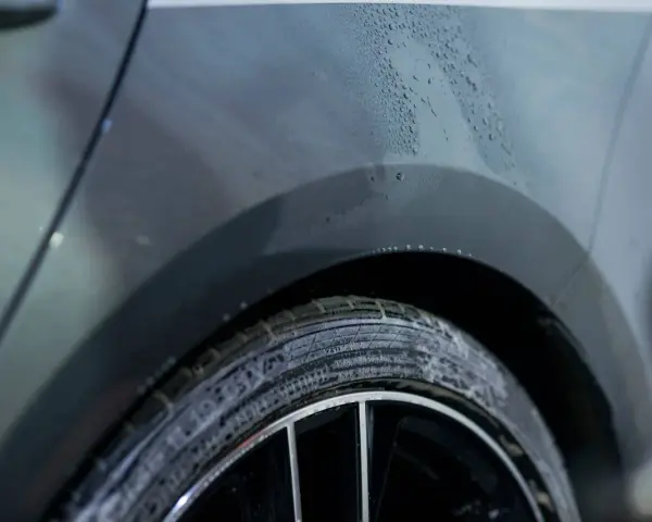 Krople wody na karoserii samochodu i spieniona opona. Pytanie: czym odtłuścić metal przed malowaniem?