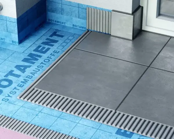 Systemowa hydroizolacja łazienki z niebieską membraną Botament i szarymi płytkami.