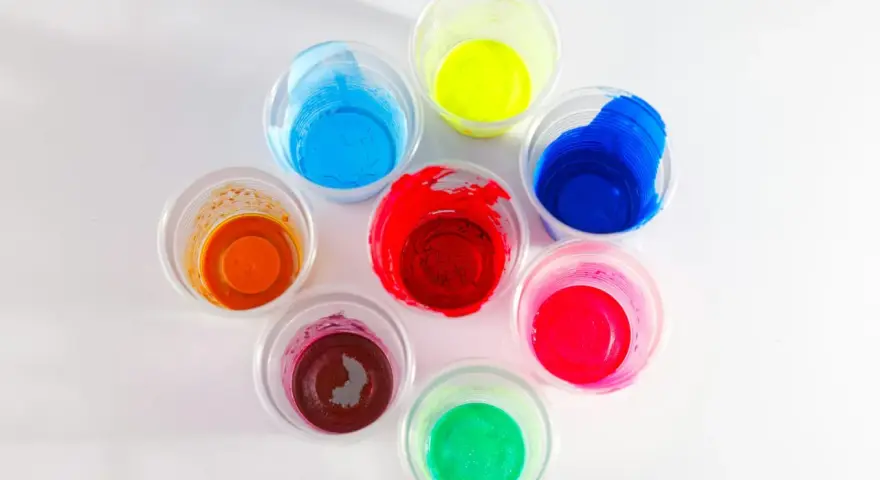 Kolorowe farby w kubeczkach, idealne jako jaka farba do plastiku na zewnątrz. Odcienie czerwieni, niebieskiego, żółtego, zielonego, pomarańczowego i różowego.